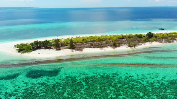 Aerial: Flying over idyllic atoll, exotic travel destination in Wakatobi National Park, Indonesia