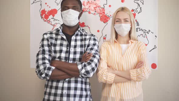 Portrait of Multi-ethnic Family in Medical Masks Against Background of World Map the Spread 