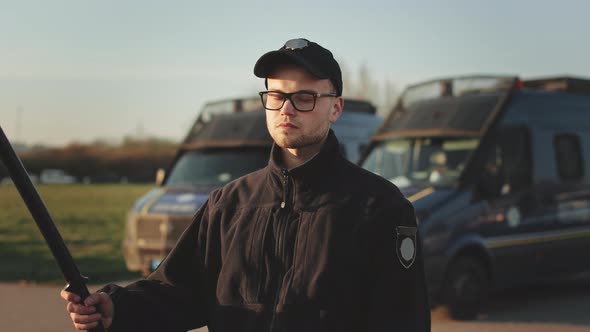 A Man in a Police Uniform is Turning His Head and Looking Seriously at the Camera