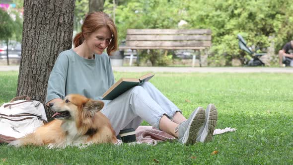 Woman Reading In A Park With Her Corgi Dog 3