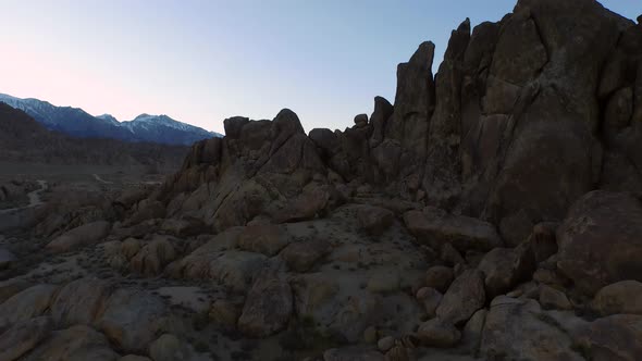 Aerial birds-eye view shot of a young man backpacker camping with his dog in a mountainous desert.