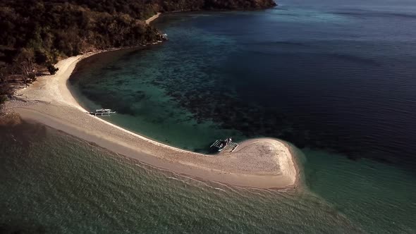 Amazing tropical island sandbar, calm water, blue ocean and boats. Aerial drone view. Location: Pala