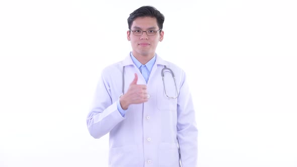 Happy Young Asian Man Doctor Giving Thumbs Up