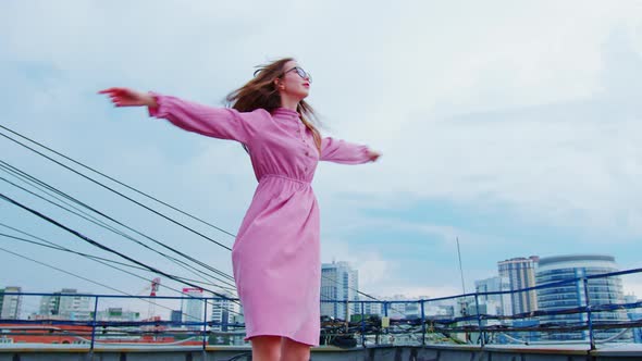 Pretty Girl is Spinning Around Her with Hands Up