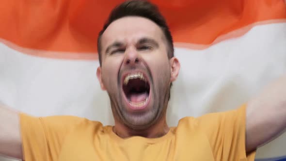 Netherlands Fan Celebrates Holding the Flag of Netherlands