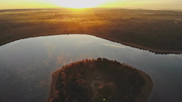 Beautiful Warm Colors Autumn Morning at a Forest Lake with Fog