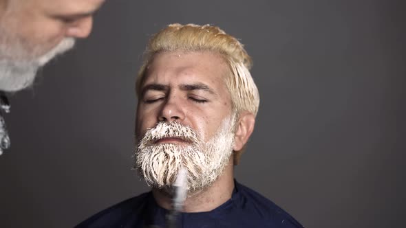 Process of a Blonde Man Having Hair Dyed at Hairdresser