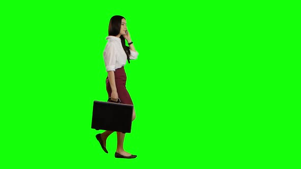 Girl Speaks on the Phone, in the Hand Holds a Diplomat. Green Screen