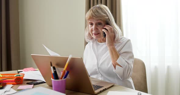 Senior Woman Working From Home During the Covid19 Pandemic Discussing Paperwork with a Client or