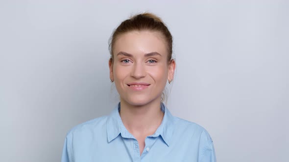 Portrait of a smiling young woman in a shirt on a white background. Happy girl manager looks at the