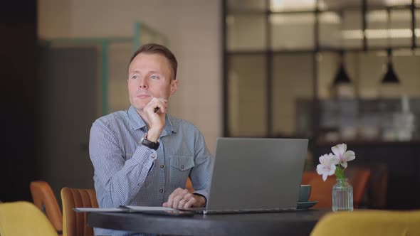 Thoughtful Serious Young Man Student Writer Sit at Home Office Desk with Laptop Thinking of