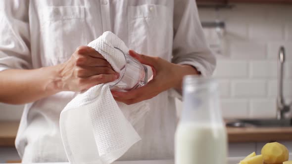 Young Woman Hostess Wipes Dishes Glass With A White Towel, Wiping Glass Kitchenware From Water