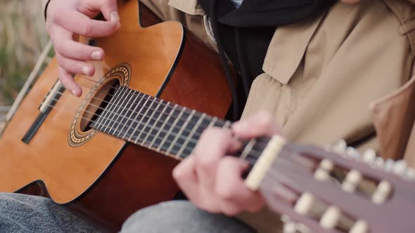 Cropped View of Male Hands Performing Song on Guitar