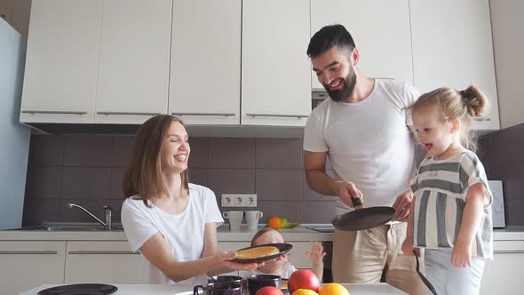 Father Having Fun with Pancakes in the Kitchen