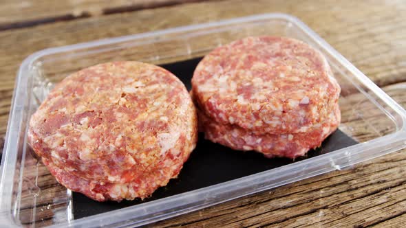 Meat patty in plastic container