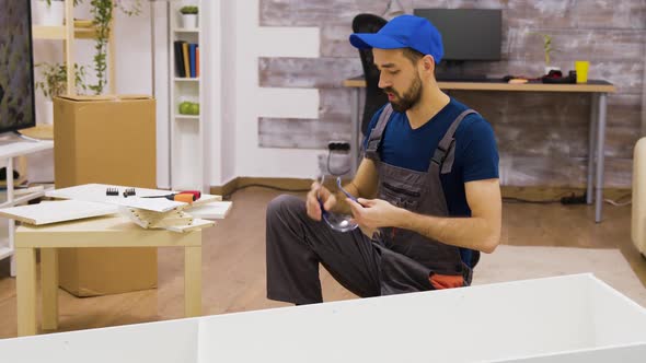 Male Worker Wearing Protection Glasses Before Furniture Assembly