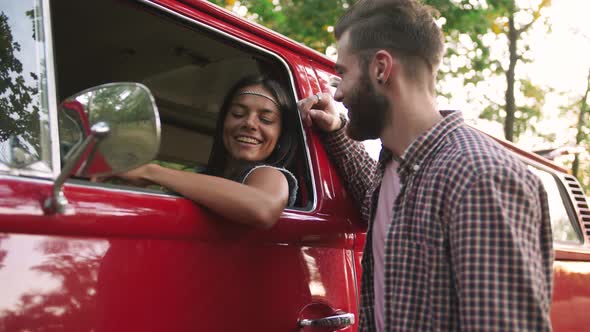 Happy Young Cheerful Mixed Race Couple Having Some Fun in Retro Hippie Minibus in Forest