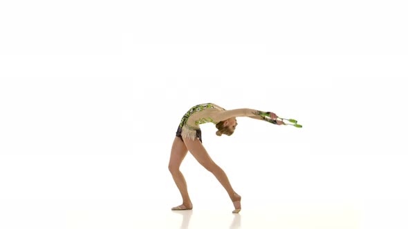 Rhythmic Gymnast Throws Mace Up and Catches Her. White Background