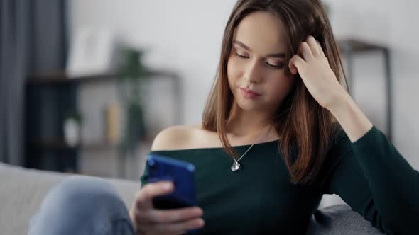 Woman Resting on Couch and Using Mobile