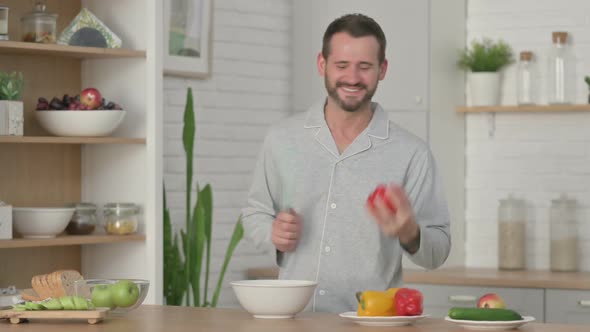 Healthy Young Man Dancing While Cooking in Kitchen
