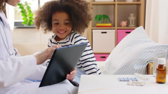 Doctor with Tablet Computer and Sick Girl in Bed