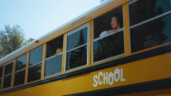 Schoolchildren Looking Out Bus Window in Morning