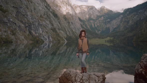 Attractive photographer with a retro camera by the lake