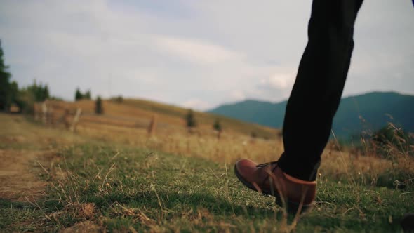 Slow Motion Man Groom or Bussinessman Legs Feet Steep Terrain on Field in Rays of Sun, Making Steps