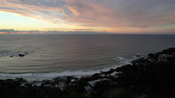 ocean view of South Atlantic at dusk with sun setting on horizon in Cape Town, aerial