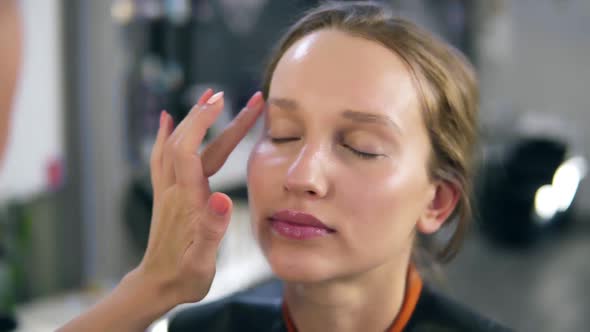 Professional Make Up Master Putting Foundation Cream on a Face