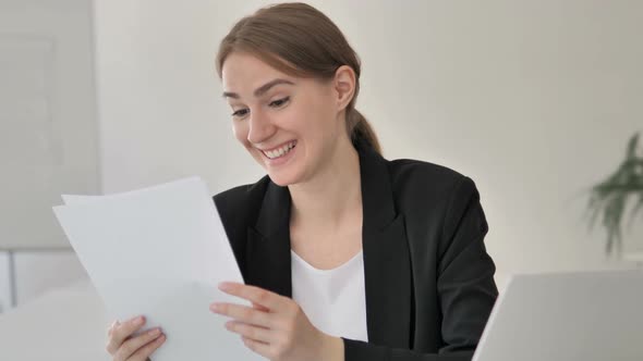 Young Businesswoman Reading Documents at Work