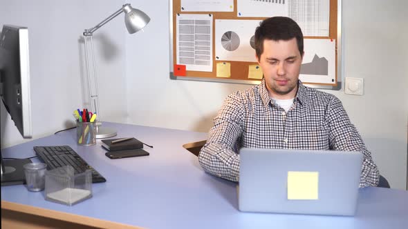 Office Worker, Who Is Busy Typing Text on a Laptop Laptop Using the Internet