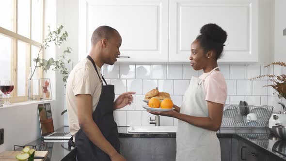 Beautiful Young Man Stands with Fruits Plate, They Have Conversation and Smile.