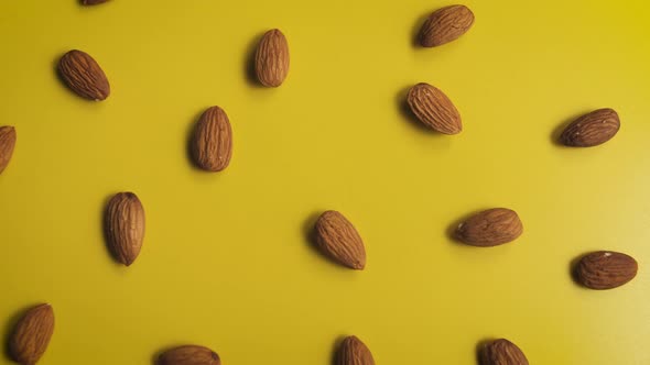 Almonds Falling From Above on a Yellow Background