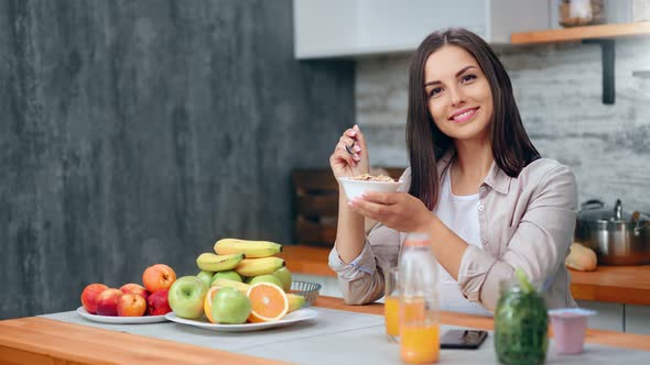 Portrait of Adorable Lady Posing with Bowl of Oatmeal at Cosiness Cuisine Looking at Camera