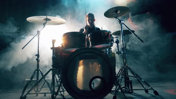 Male Drummer Is Playing the Drum Kit in the Shadows and Smoke