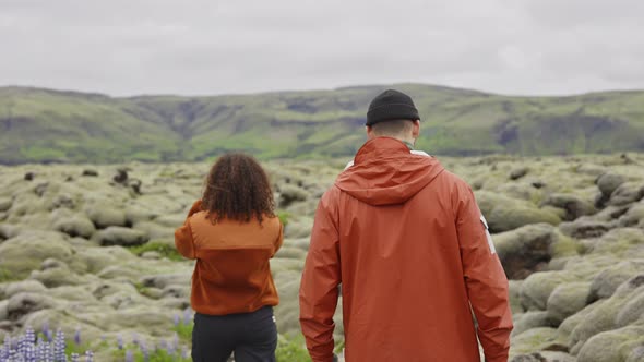 Young Couple Hiking Through Moss Covered Landscape