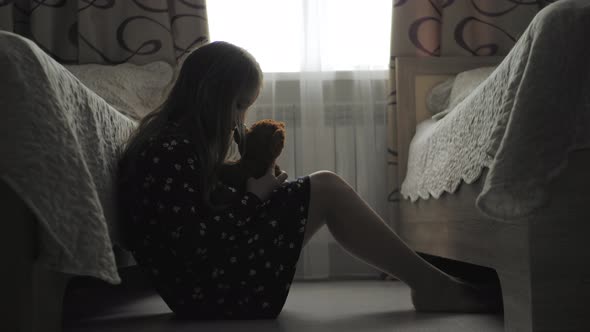 Depressed Little Girl Hugging Teddy Bear