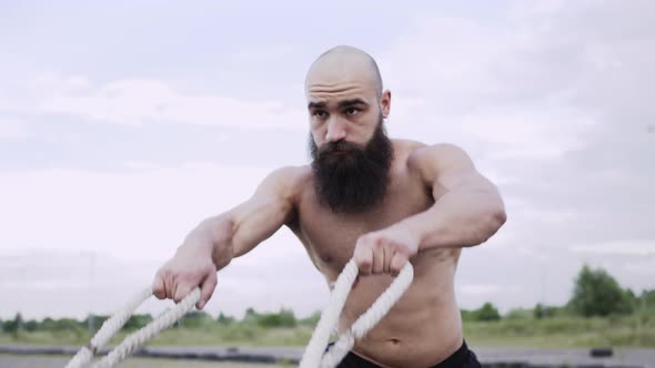 Athlete Trains On The Street. Strong Young Man With Beard.