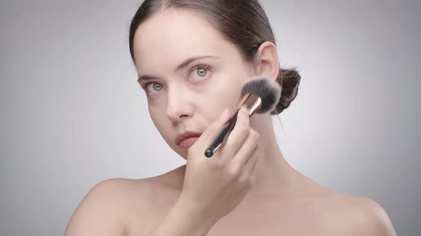 Woman Doing Makeup with Powder