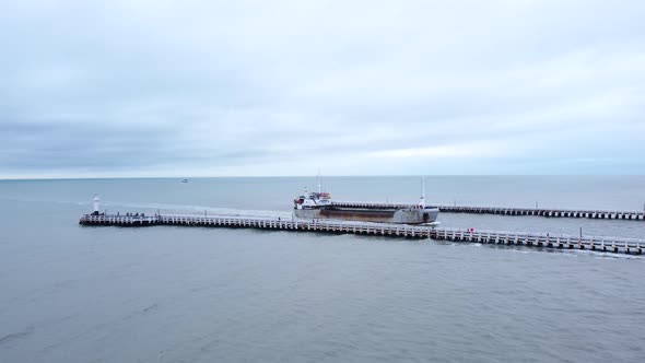 Cargo Ship Sailing into Port between Jetty, Returning from Sea AERIAL