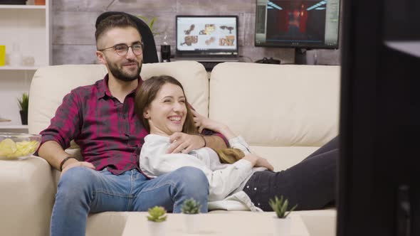 Couple Sitting on the Couch and Laughing