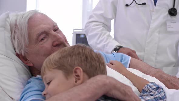 Loving Grandfather Hugging Grandson in Hospital Ward