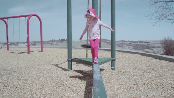 Little girl playing on outdoor children playground in suburban neighborhood.
