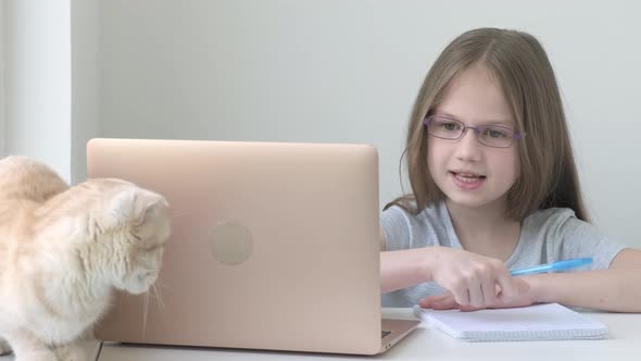 School Girl in Glasses Studying Online Using Laptop at Home