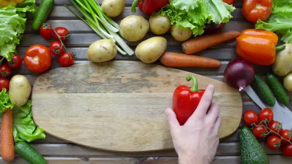 Hands of Male Chef Putting Bell Pepper on Cutting Board