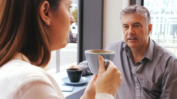 Businessman interacting with businesswoman in office cafeteria