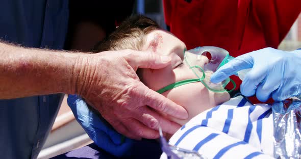 Paramedics examining injured boy