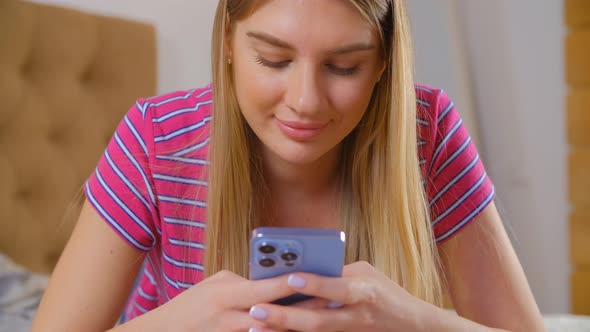 Young blonde girl using modern smartphone for communication online in 4k video