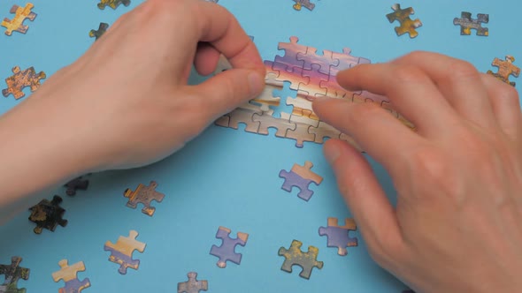 Unfinished Puzzle Pieces on Blue Background. Assemble Puzzle with Dramatic Sky. Hands Assembling